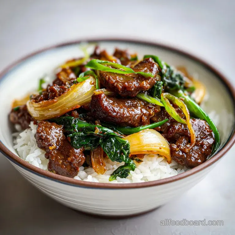 Stir-fried beef and onions artfully plated, glistening with savory sauce and topped with green onion, hinting at fresh gin...