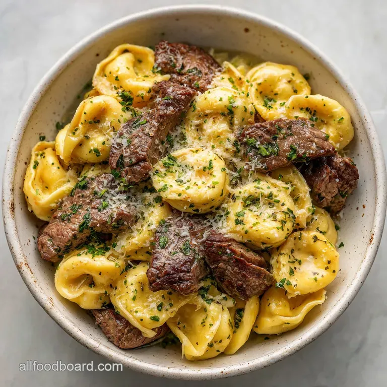 Elegant plate of cheesy tortellini and tender steak, drizzled with a rich, buttery sauce and topped with fresh parsley spr...